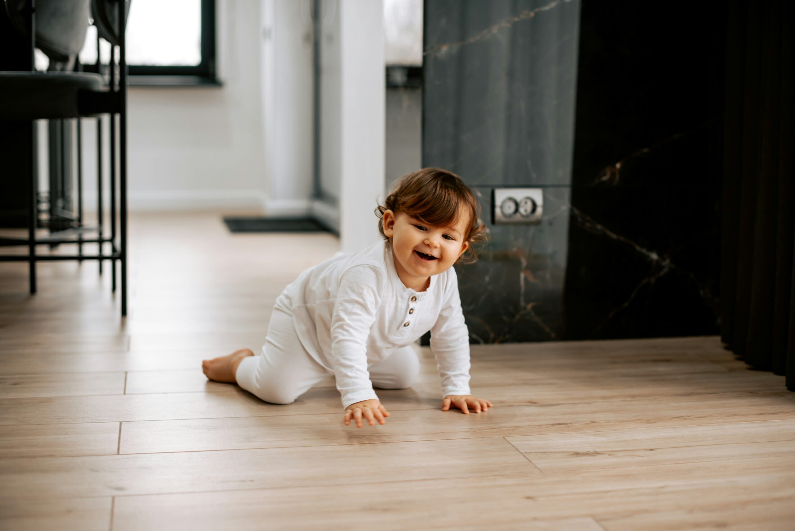 Baby crawling on hands and knees, smiling.